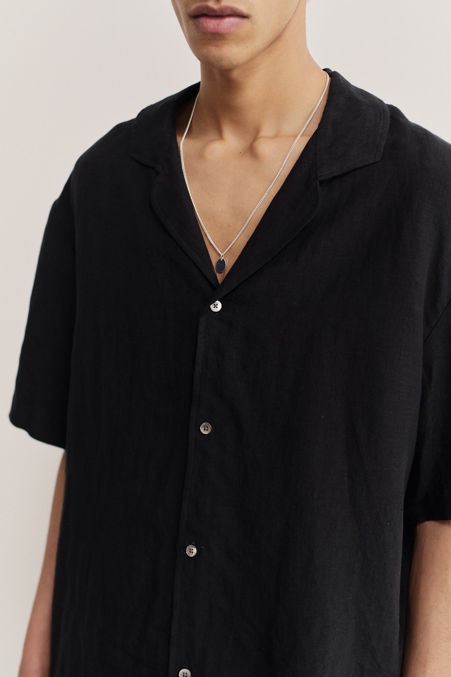 Men's short-sleeved shirt, 100% linen, natural black, with notched collar and dropped shoulders.