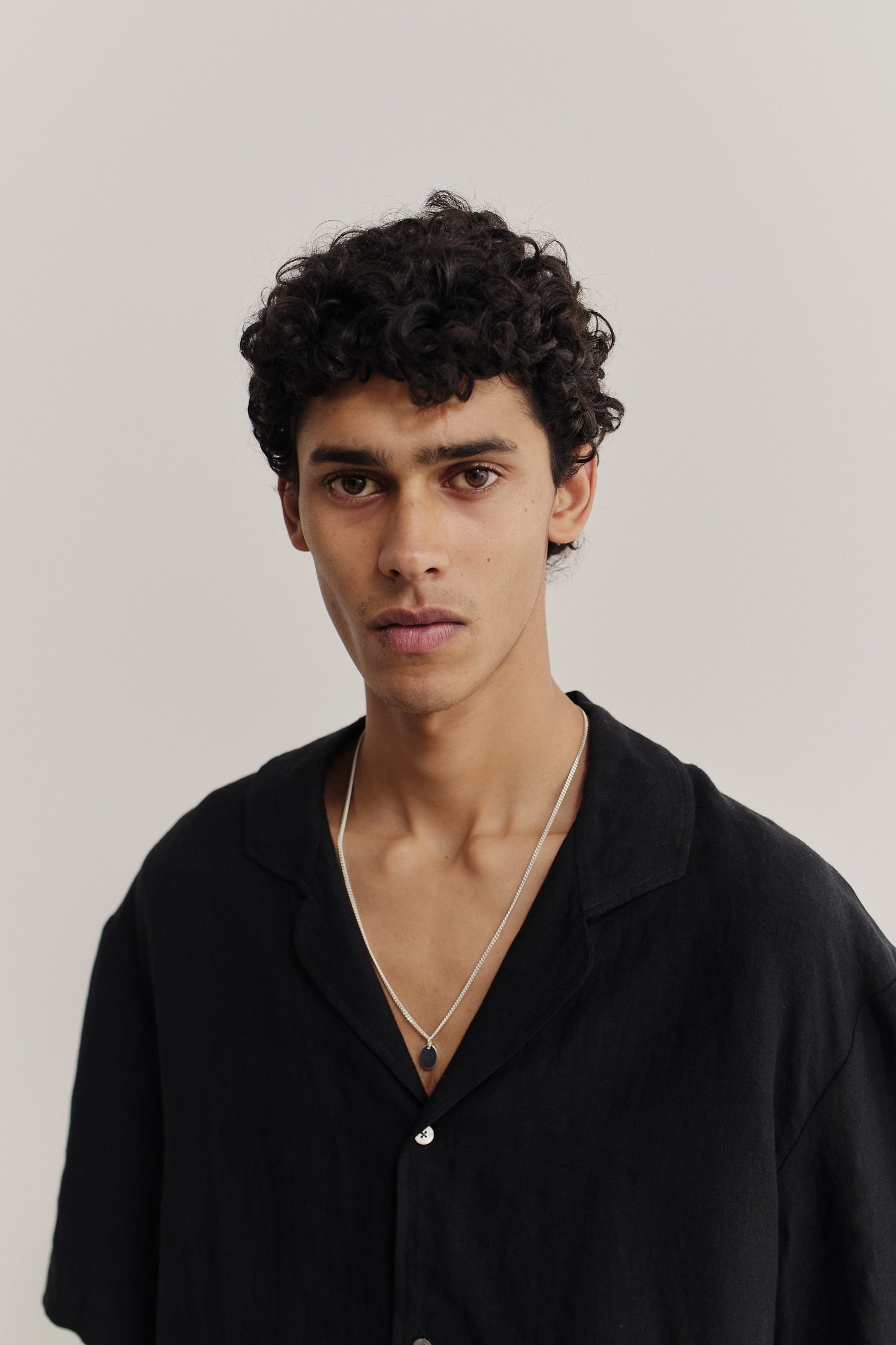 Men's short-sleeved shirt, 100% linen, natural black, with notched collar and dropped shoulders.