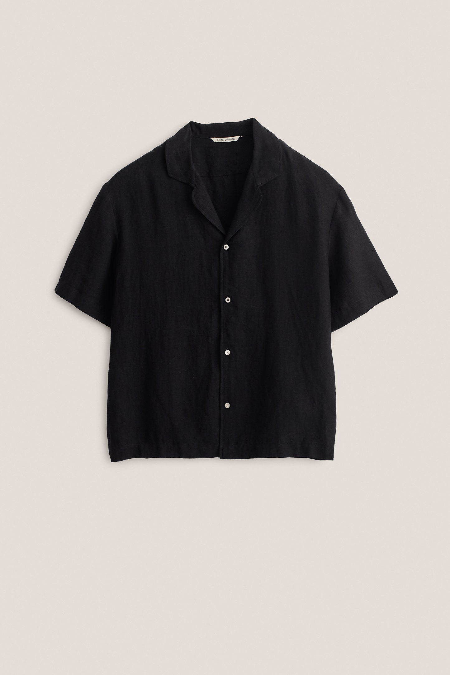 Men's short-sleeved shirt, 100% linen, natural black, relaxed fit, notched collar, white buttons.