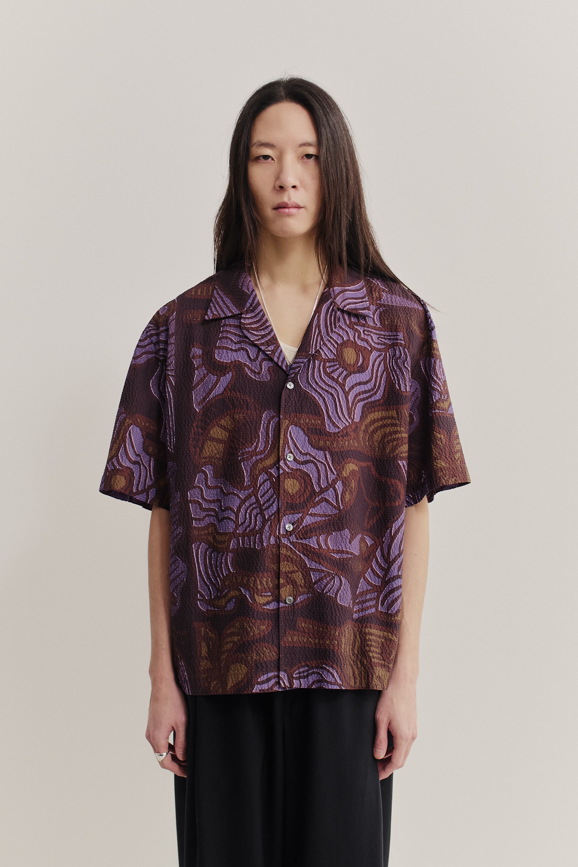 Men's short-sleeved shirt, cotton seersucker, brown with purple African wildlife print, notched collar.