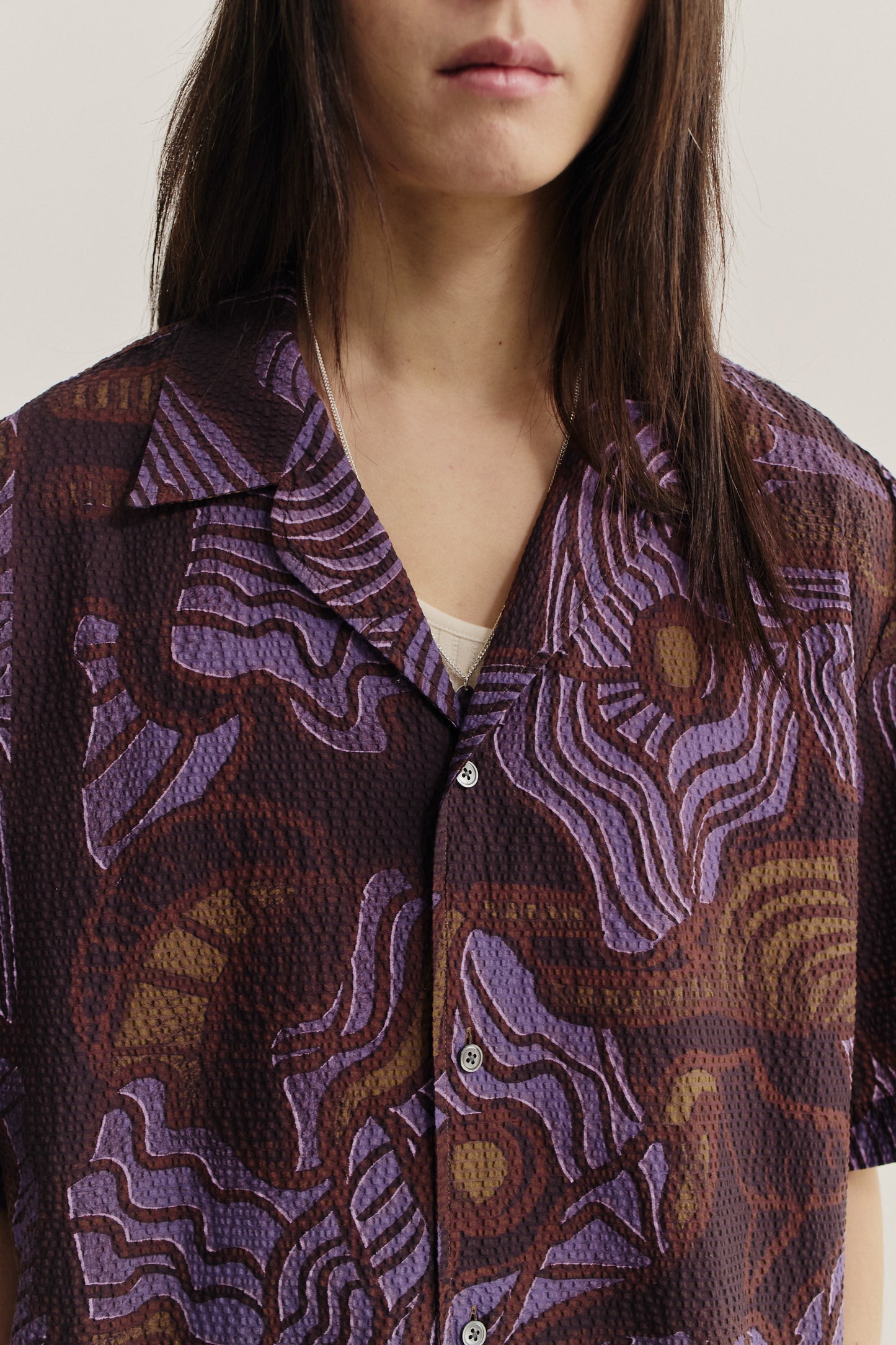 Men's short-sleeved shirt, cotton seersucker, brown with purple African wildlife print, notched collar.