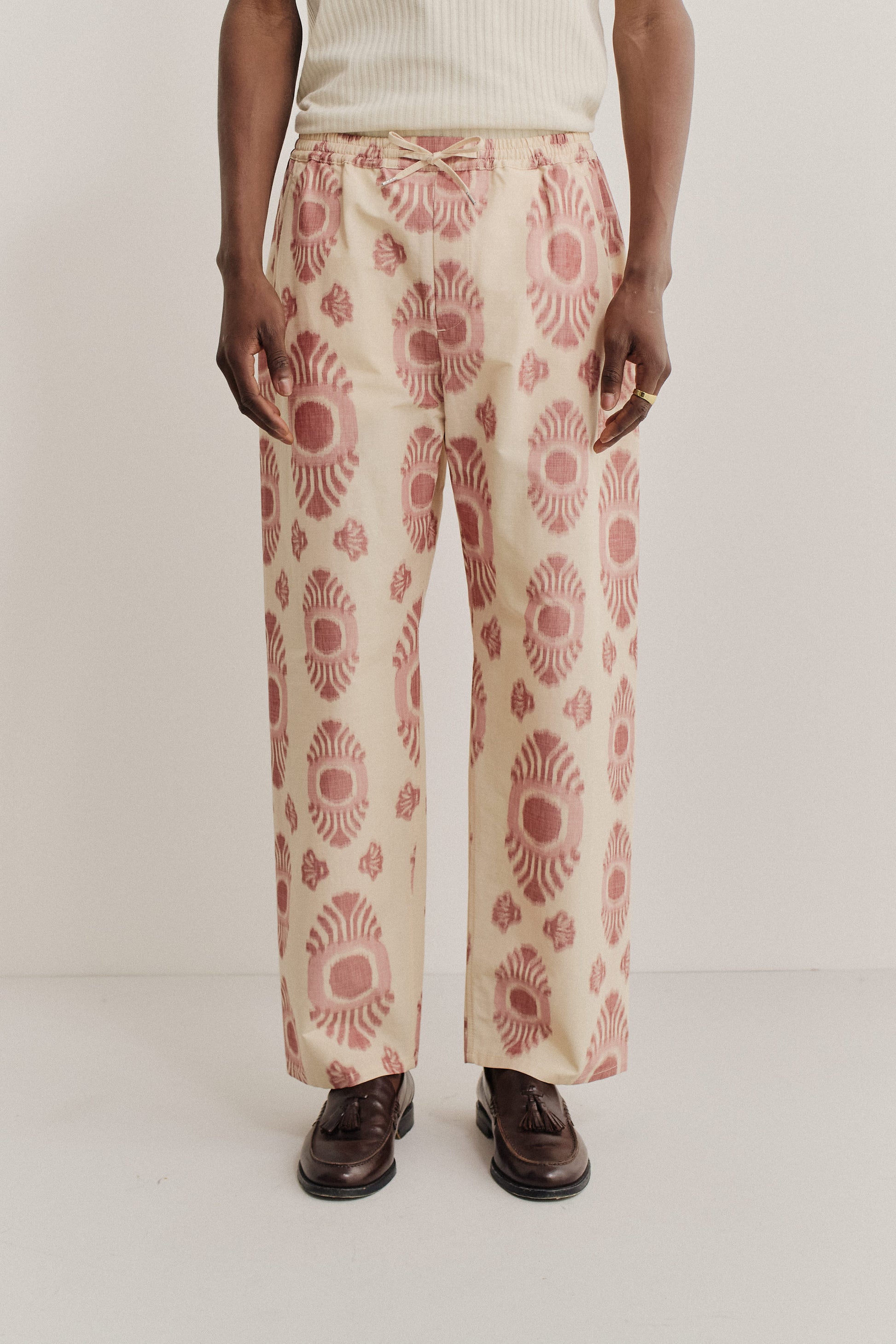 Men's long-pants, cotton and recycled polyester blend, ikat pattern, beige with red motifs.