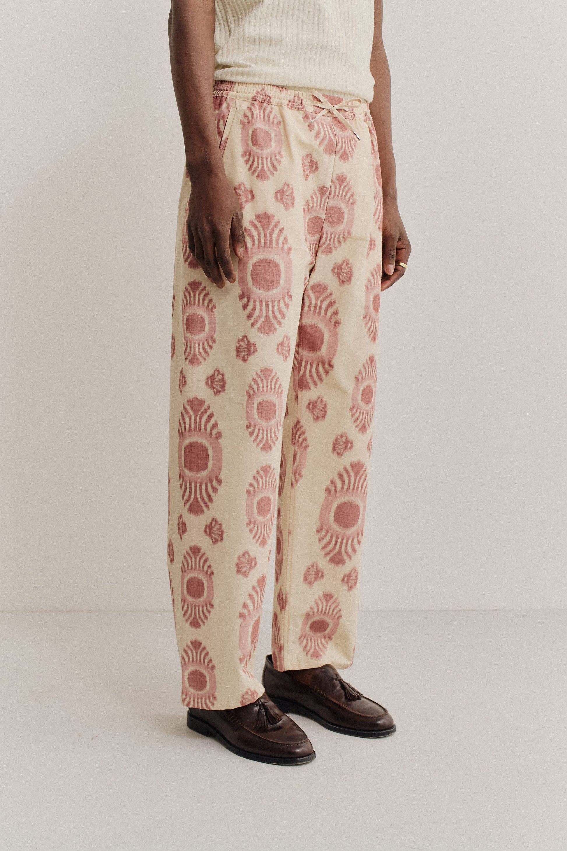 Men's long-pants, cotton and recycled polyester blend, ikat print, beige with red pattern, relaxed fit.