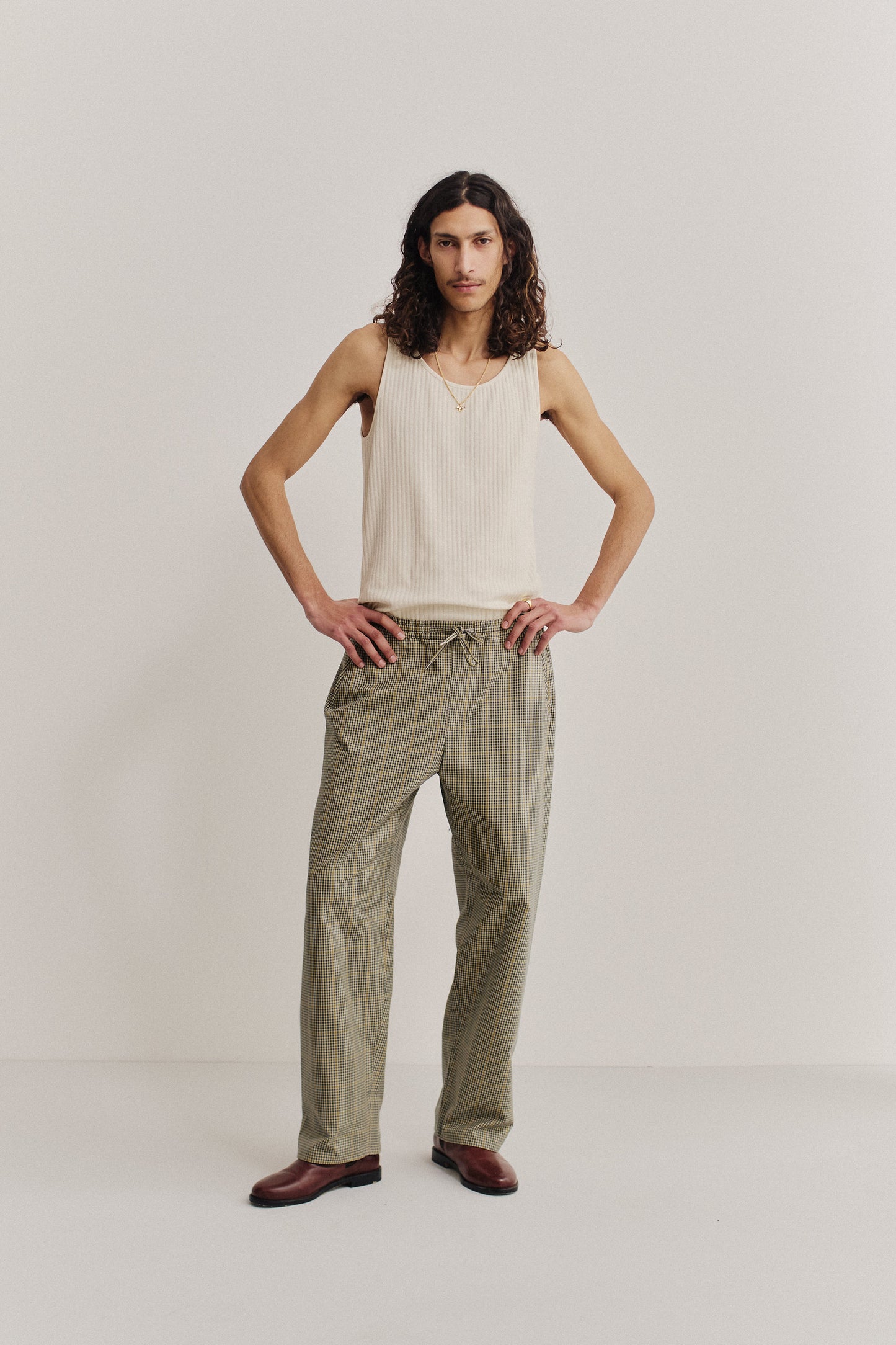 Men's long-pants, cotton houndstooth in navy, green, and beige with yellow lines.