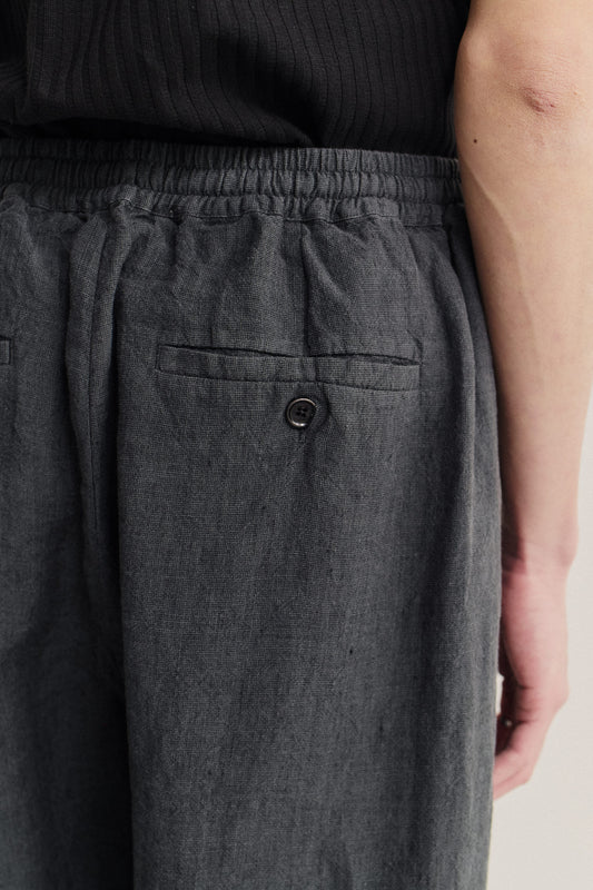 Men's long-pants, 100% linen, plain weave, dark grey, with elasticated waistband and buttoned welt pocket.