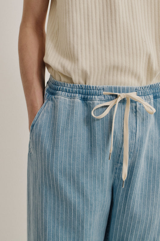 Men's long-pants, organic cotton, washed light blue denim with white pinstripes, elasticated waist, and drawstring.
