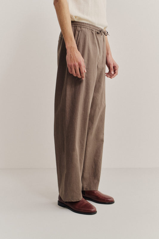 Men's long-pants, 100% linen, natural brown, wide straight fit, elasticated waistband, welt pockets.