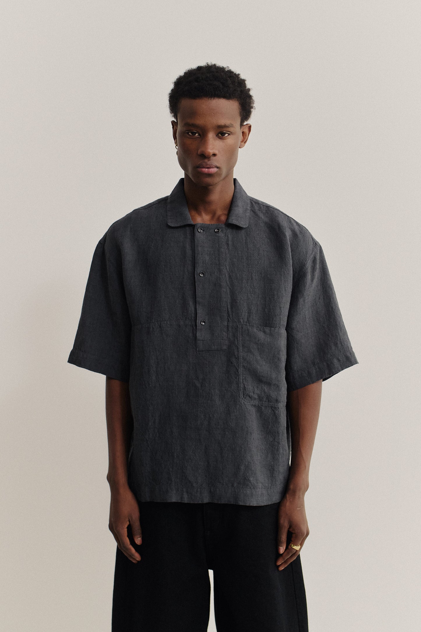 Men's short-sleeved shirt, 100% linen, plain weave, charcoal grey, with a polo collar and front pocket.