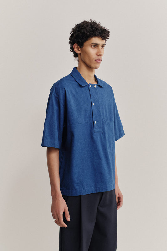 Men's short-sleeved shirt, washed indigo cotton, boxy fit, polo collar, and chest pocket.