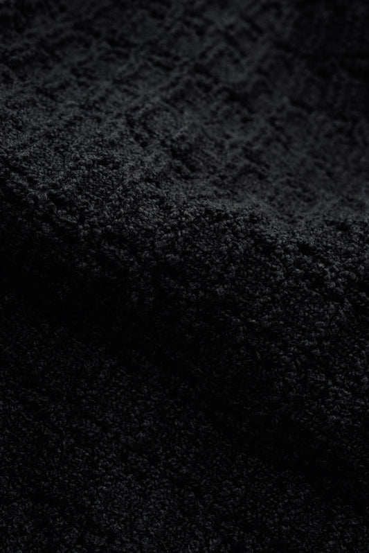 Men's knit vest, black organic cotton-wool bouclé with openwork knit pattern, tactile surface.