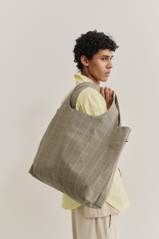 Men's accessories, Thika Bag, 100% cotton, checkered houndstooth pattern in navy blue, green, and yellow on beige.