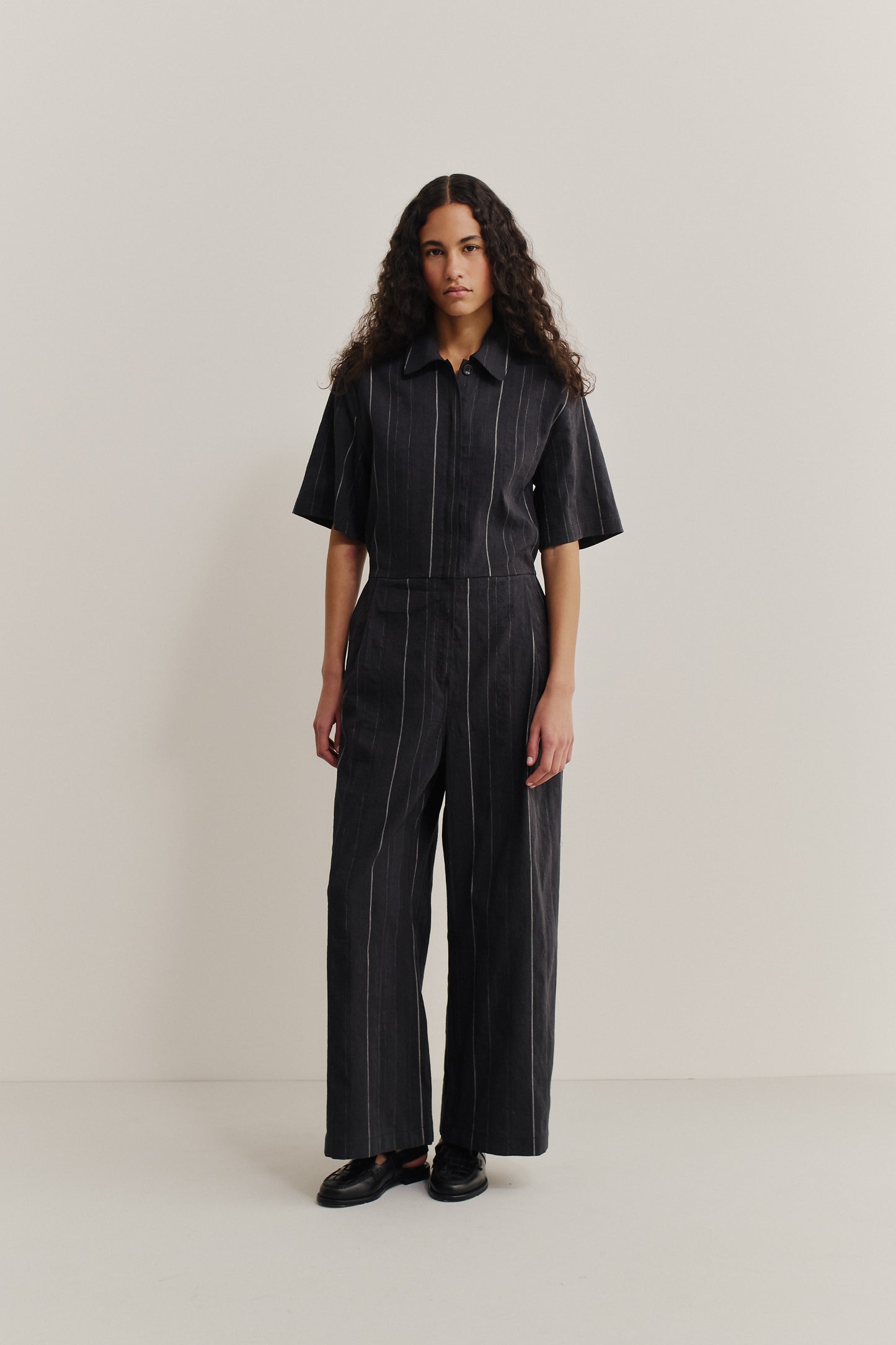 Women's jumpsuit, short-sleeved, wide-leg, cotton-linen blend, faded black with white stripes.