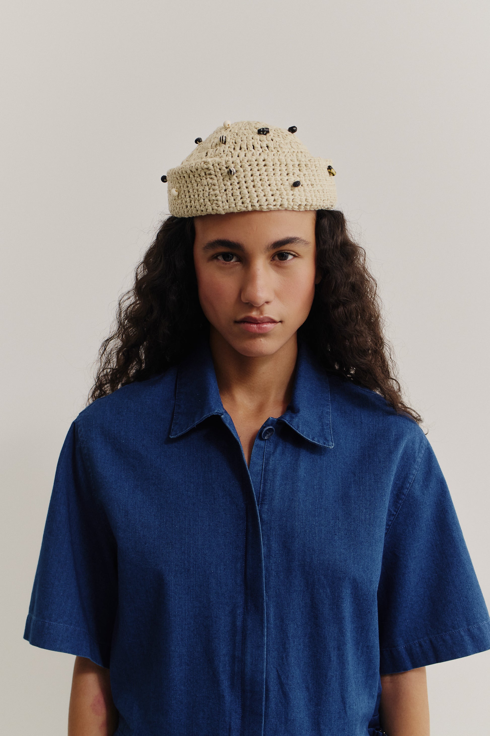 Women's short-sleeved jumpsuit, washed indigo cotton, with a lay-down collar and hidden zipper.