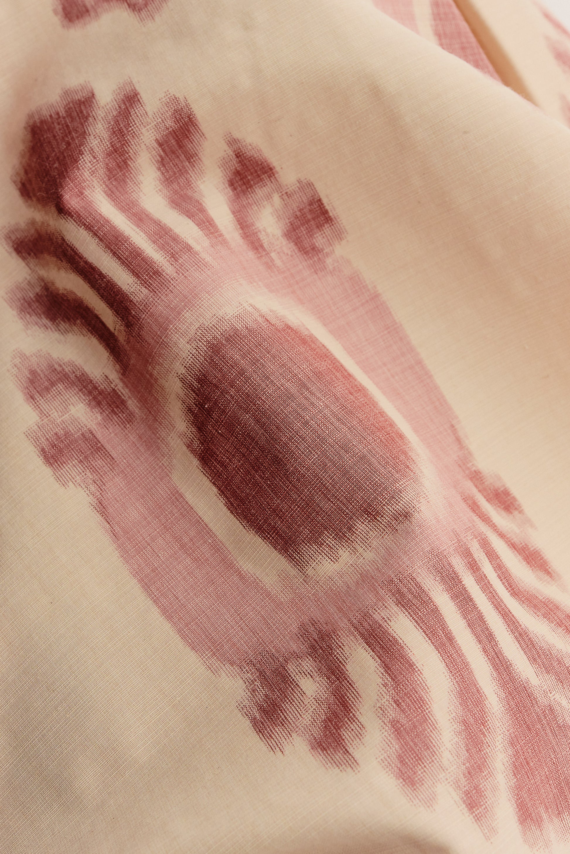 Men's shorts, cotton and recycled polyester blend, lightweight, off-white with red ikat-inspired pattern.
