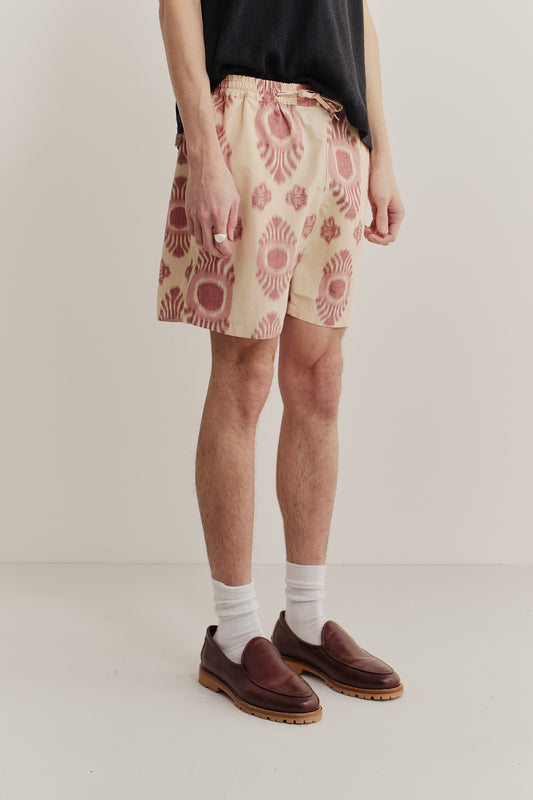 Men's shorts, cotton and recycled polyester blend, ikat-patterned in beige and red.