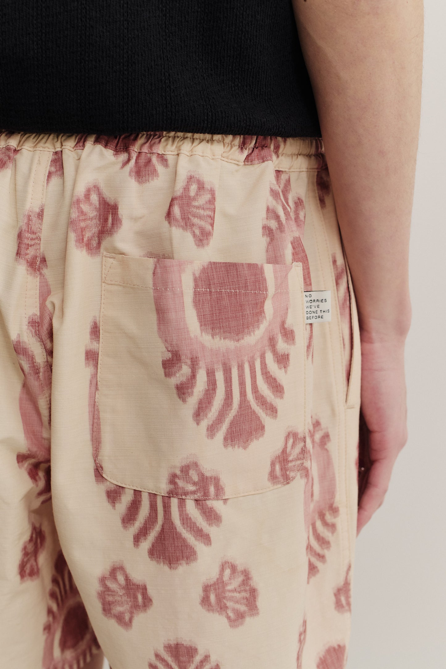 Men's shorts, cotton and recycled polyester blend, ikat-printed, beige with red pattern, back patch pocket.
