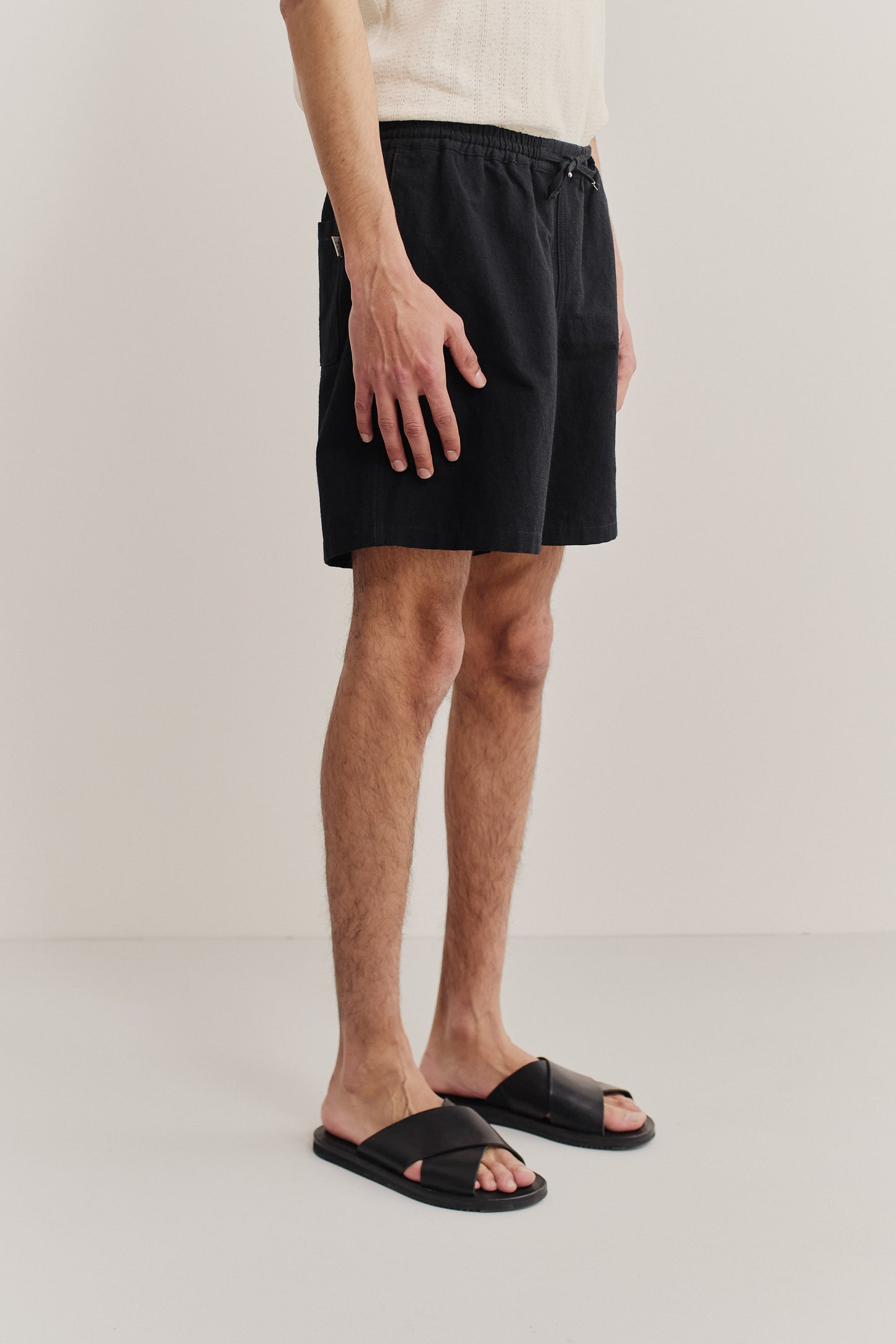 Men's shorts, worsted wool and linen blend, black, with adjustable waistband and side pockets.