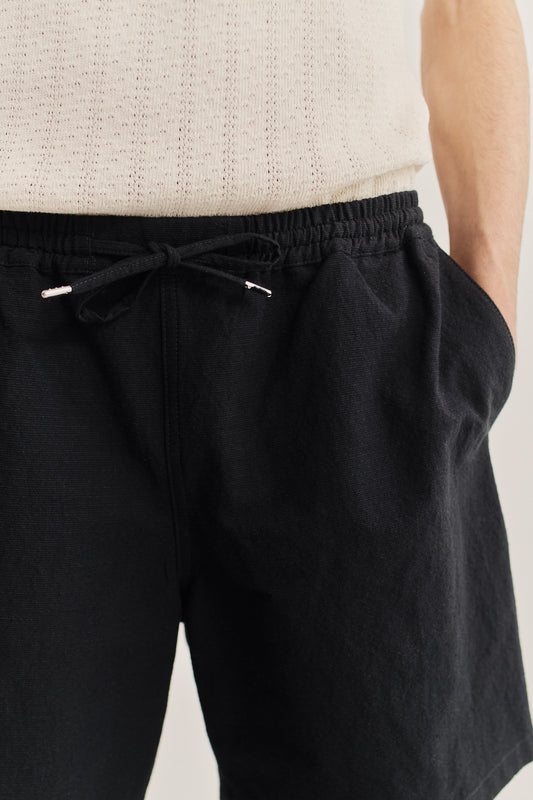 Men's shorts, worsted wool and linen blend, black, with adjustable drawstring waist and side pockets.
