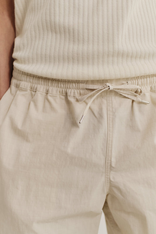 Men's shorts, cotton blend ripstop, beige, with adjustable drawstring waist and side pockets.