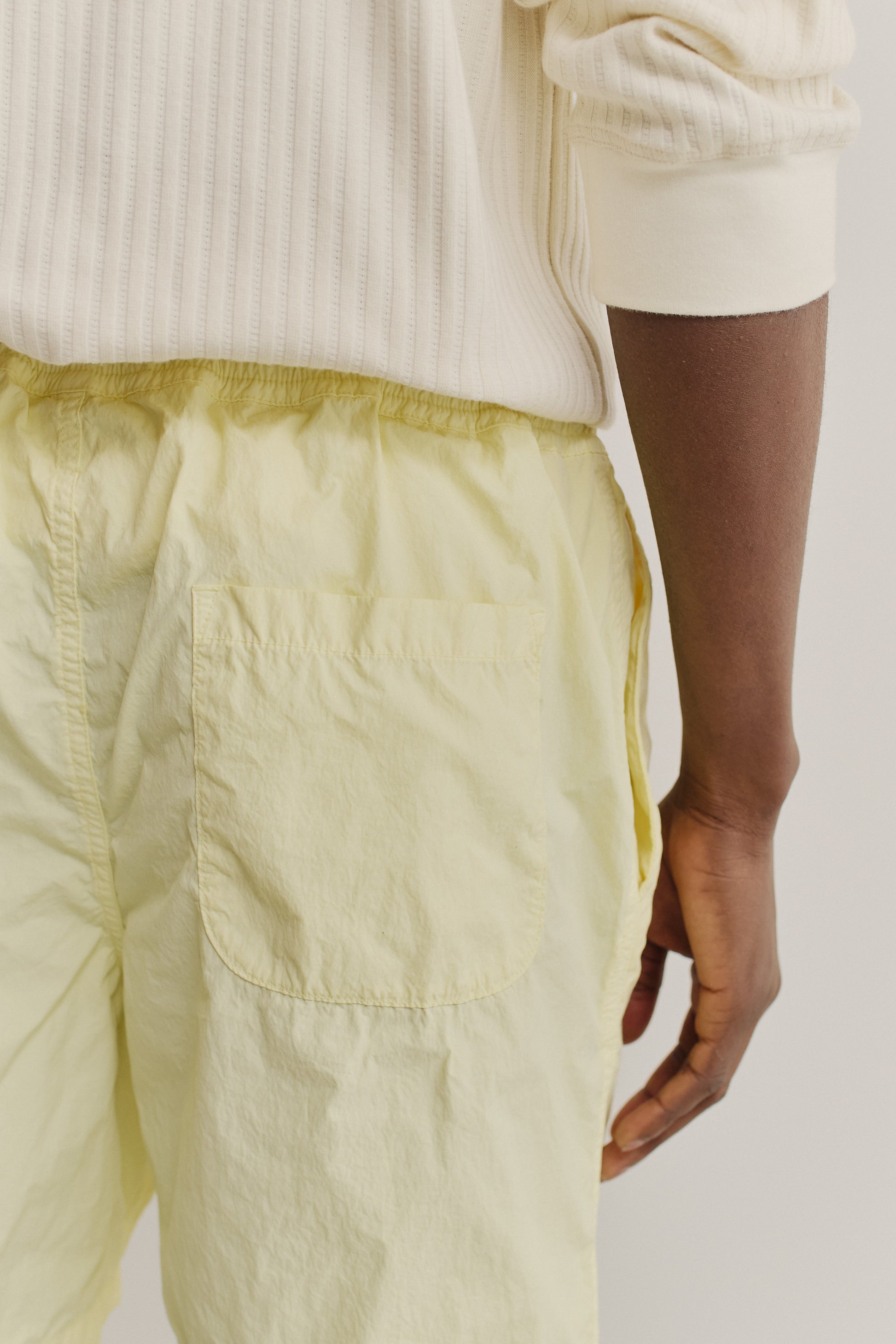 Men's shorts, recycled polyamide, garment-dyed light yellow, with a back patch pocket and side seam pockets.