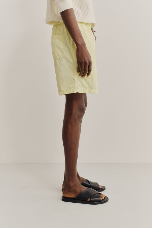 Men's shorts, recycled polyamide, garment-dyed light yellow, with side pockets and drawstring waist.