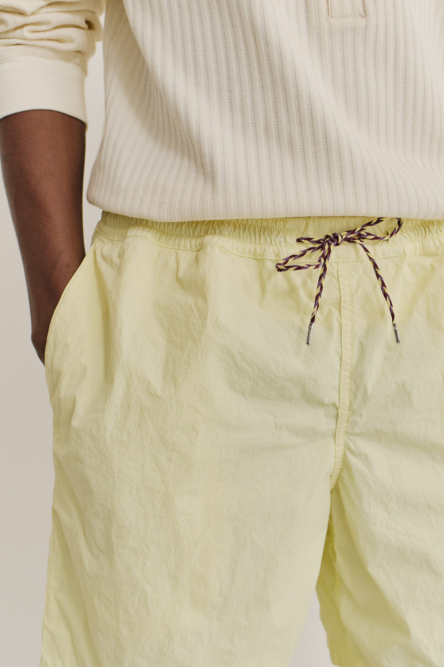 Men's shorts, recycled polyamide, garment-dyed light yellow, with adjustable waistband and pull cords.