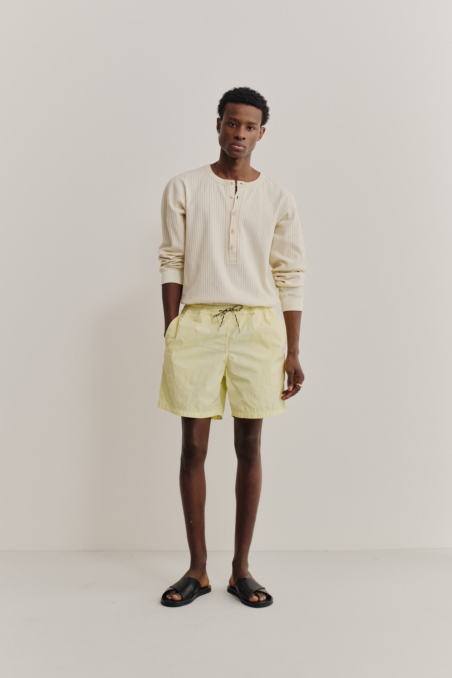 Men's shorts, recycled polyamide, garment-dyed washed light yellow, with black drawstring.