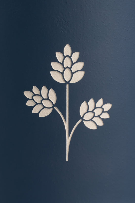 White engraved hop plant detail on a dark blue stoneware beer mug.
