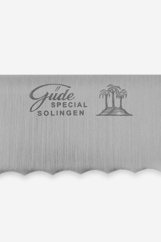 Silver hand-forged chrome steel bread knife with serrated edge and "Güde Special Solingen" logo.