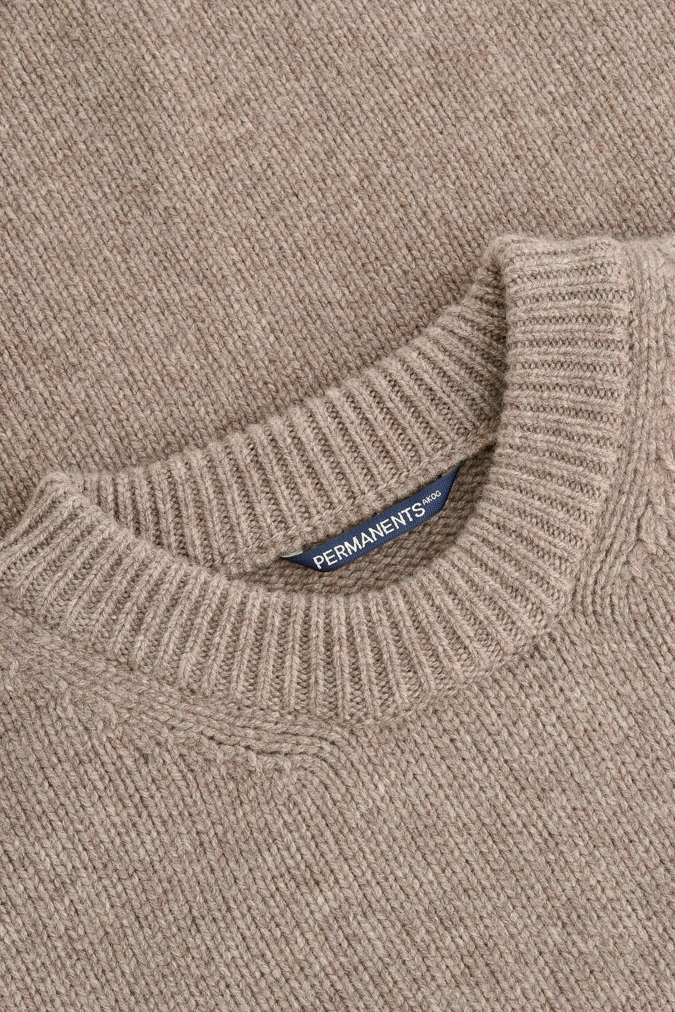 Men's knit pullover, taupe melange merino wool-cashmere blend, with ribbed neck and "PERMANENTS" label.