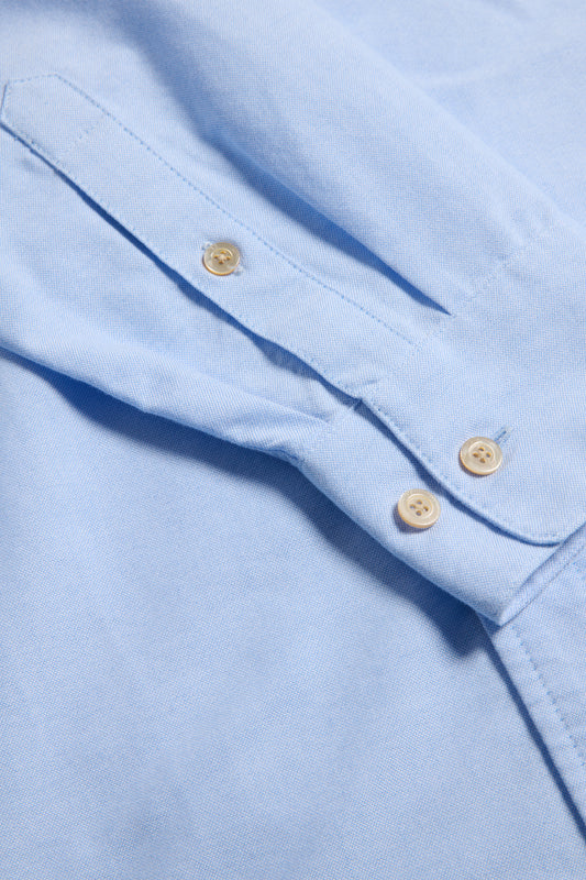 Unisex long-sleeved shirt, light blue organic cotton, featuring pearl buttons and button cuffs.