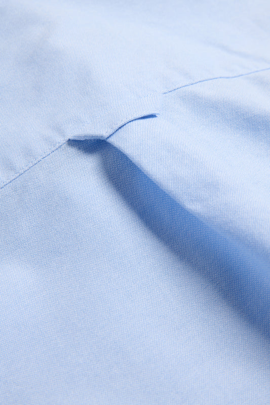 Unisex long-sleeved shirt, organic cotton, light blue, with a pocket detail and pearl buttons.