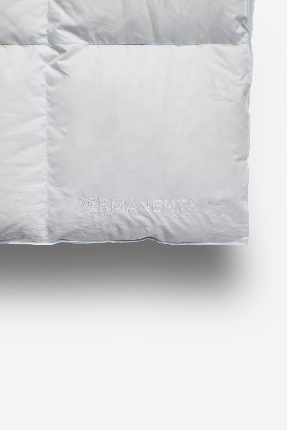White cotton Eiderdown Duvet with subtle PERMANENTS® logo, featuring quilted squares.