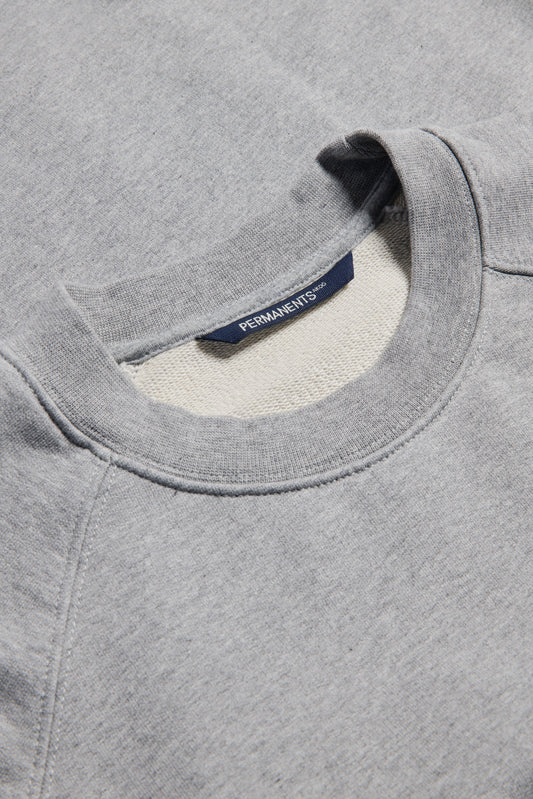 Unisex knit sweater, grey melange organic cotton, pre-washed heavy jersey with raglan sleeves and discreet logo.