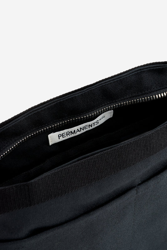 Unisex accessories bag, recycled Ventile® cotton, black, with visible zipper and "PERMANENTS" label inside.