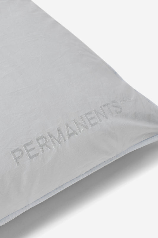 White eiderdown pillow with "PERMANENTS" embroidered logo, soft fabric, and light blue stitching.